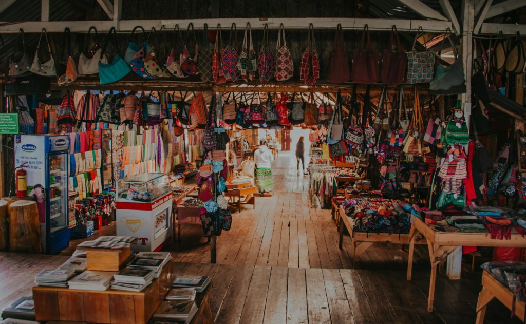 Large wooden steps lead down into a market overflowing with books and colourful bags and textiles.