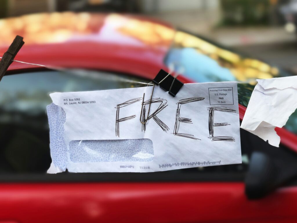 An envelope with the word "free" written in capital letters is attached to a clothesline with a bulldog clip.