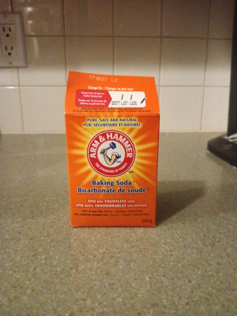 A box of Arm & Hammer baking soda sits on a grey counter.