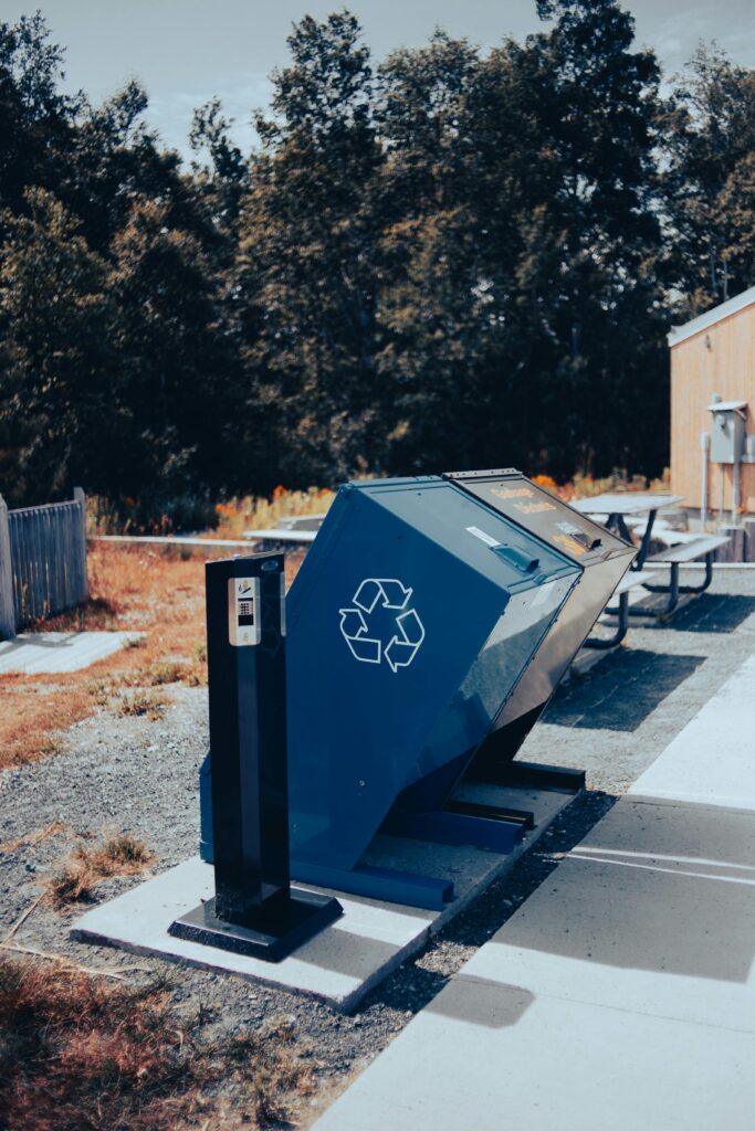 Two public bins for waste collection, one with the recycling symbol.