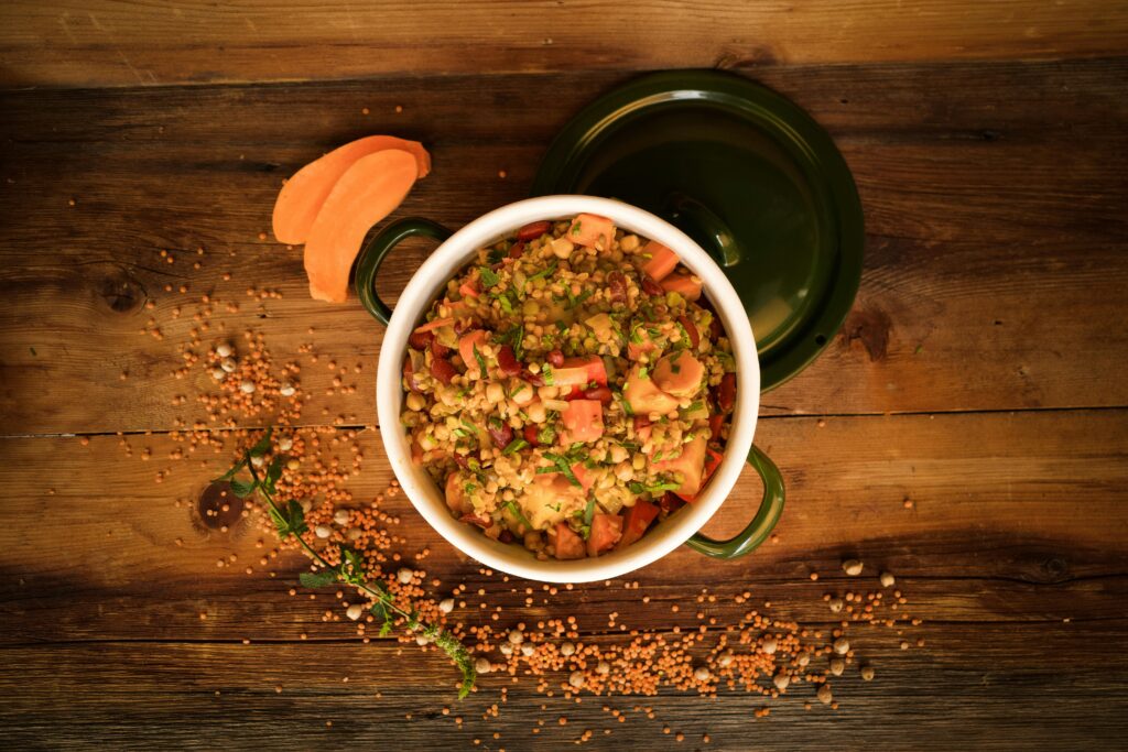 A pot containing a dish with lentils and vegetables.