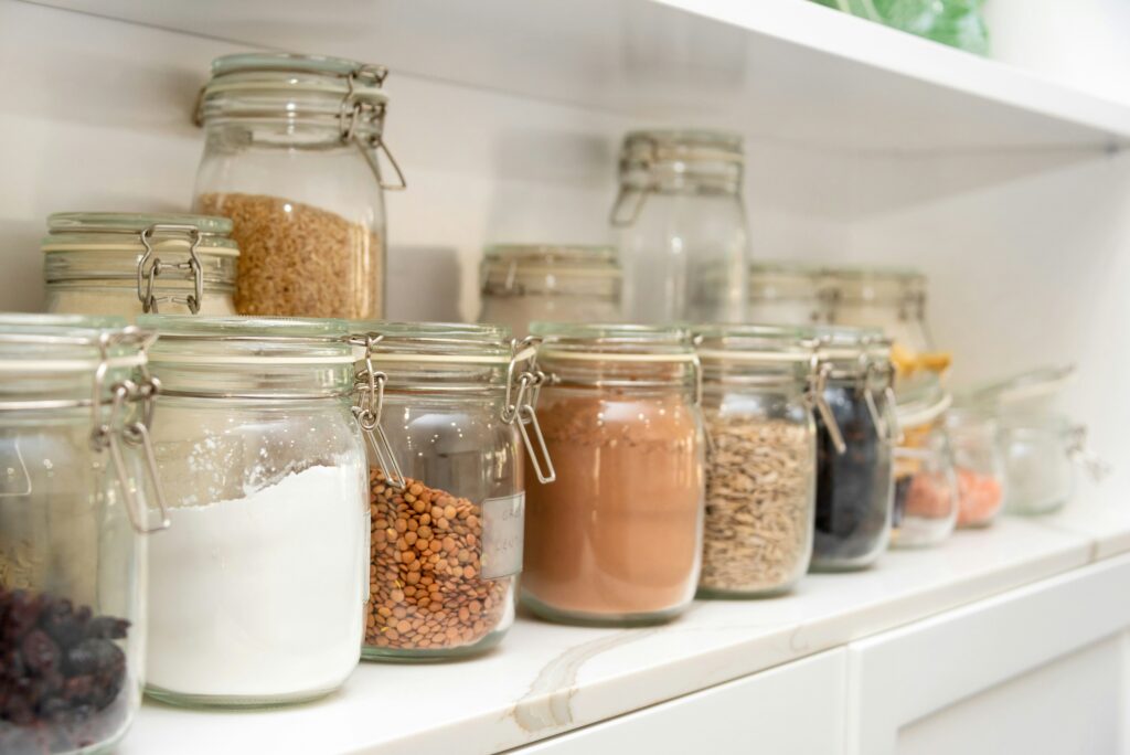 Jars of dried goods sit on a shelf.