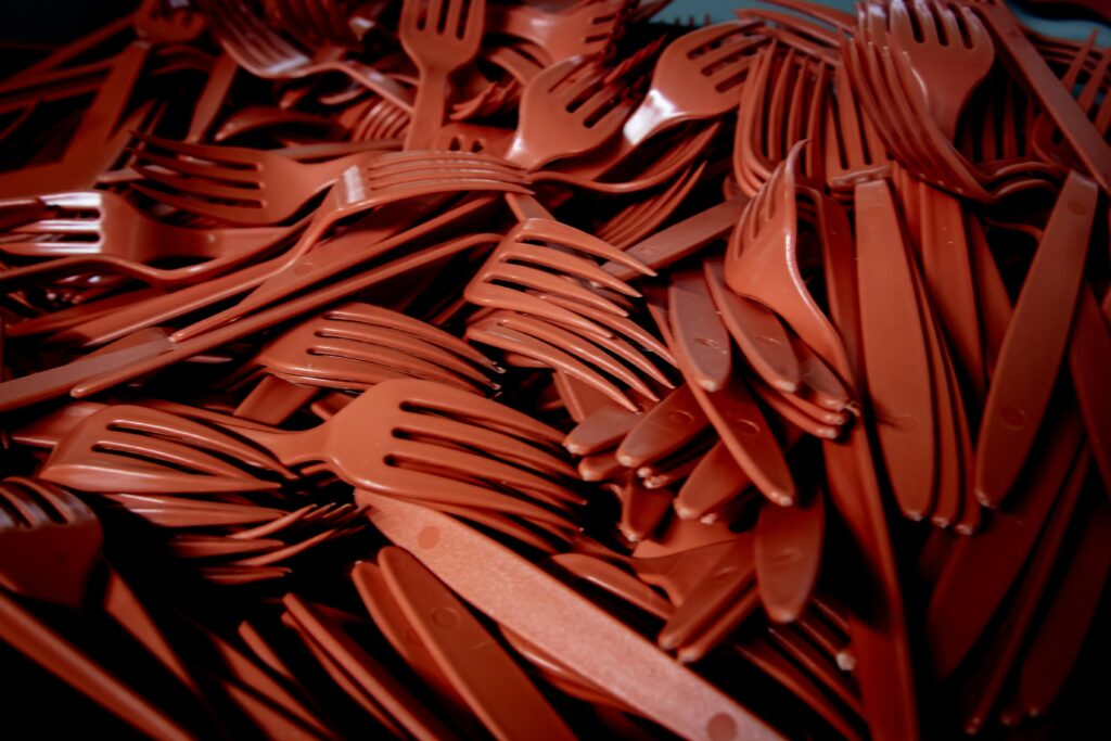 A pile of red plastic forks.